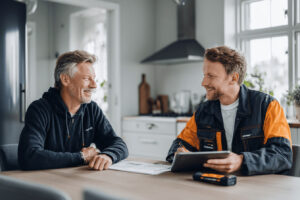 VVS-tekniker går igenom kostnaden för bergvärme 2025 med en villaägare vid köksbordet.