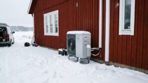Luft-vattenvärmepump installerad utomhus vid villa i Stockholm under vinterförhållanden.