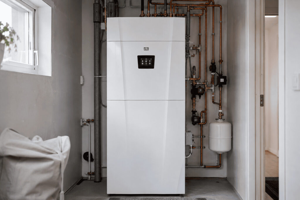 Nyinstallerad CTC-värmepump i ett svenskt teknikutrymme med synliga rör och professionell installation.